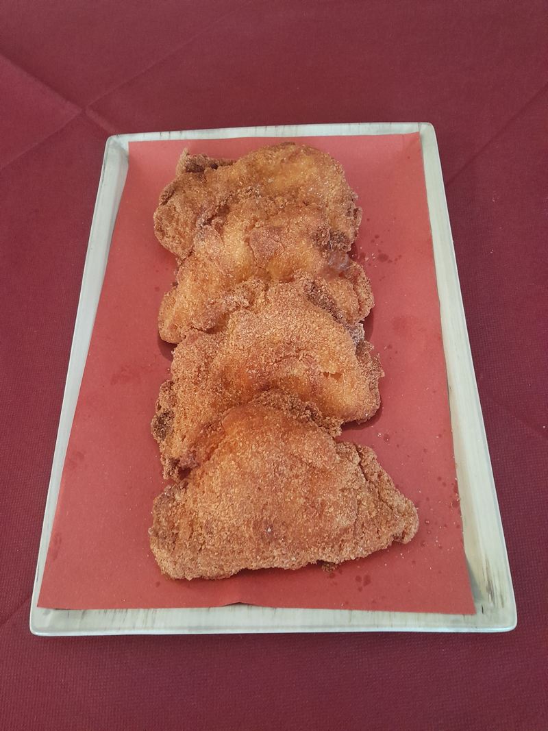 Vassoio con quattro cotolette impanate alla lubianese su carta rossa