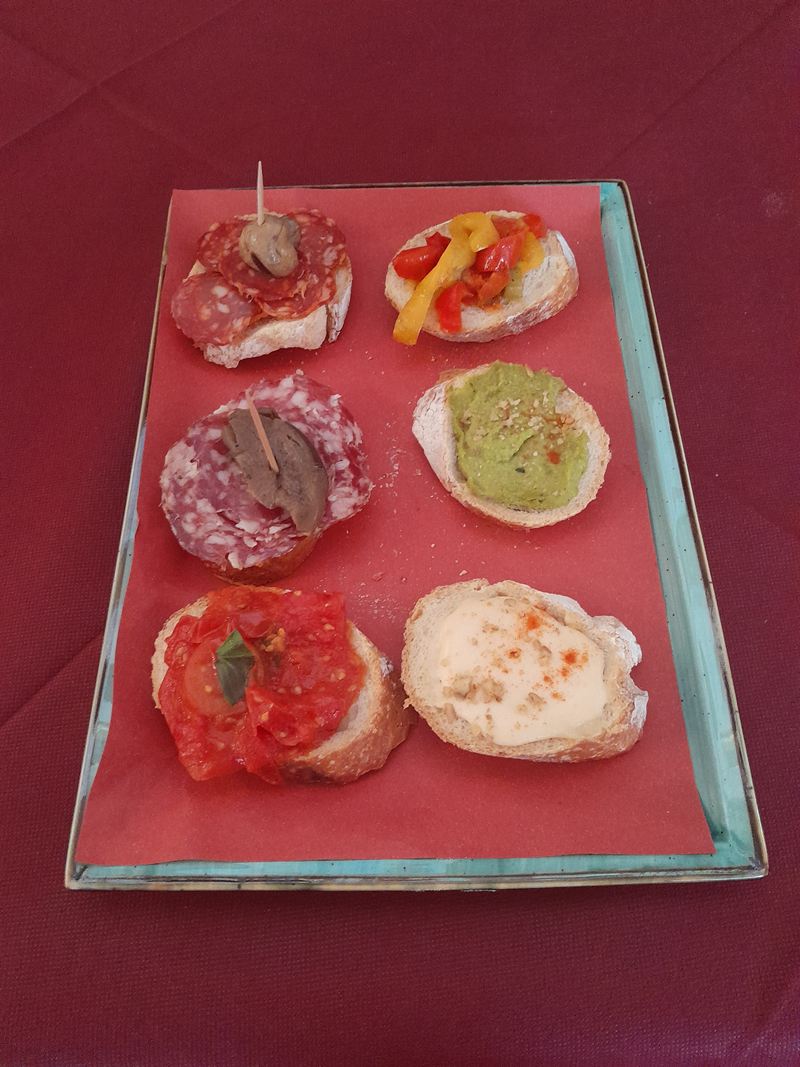 Vassoio con sei tartine assortite: salame con funghetto, peperoni, crema verde, pomodoro e formaggio