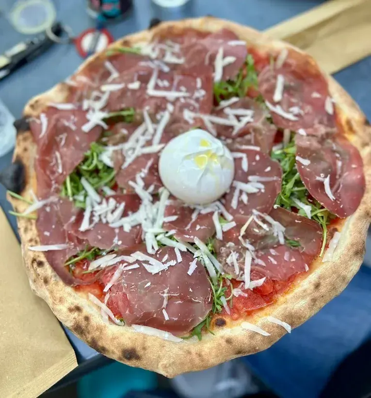 Pizza con bresaola, rucola e scaglie di formaggio
